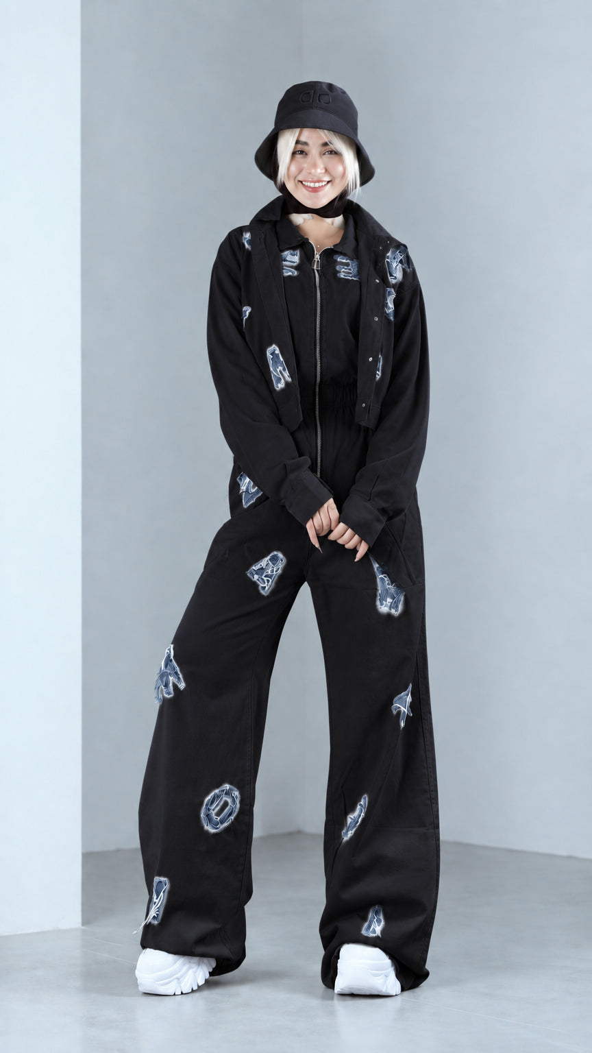 Full front view of model in black distressed two-piece jacket and pants set