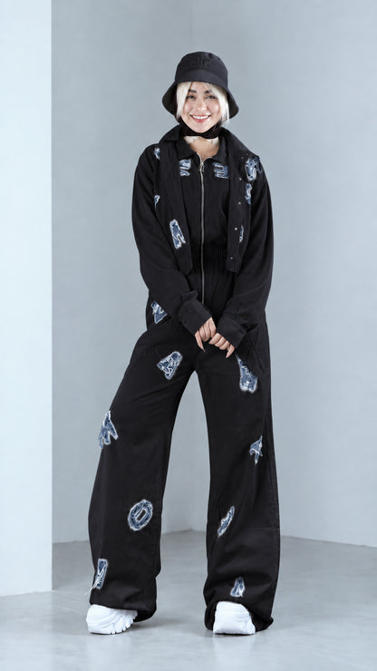 Full front view of model in black distressed two-piece jacket and pants set