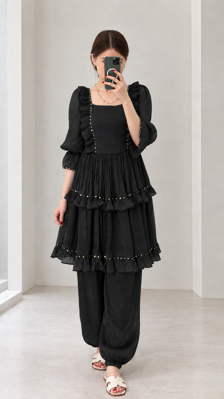 Front view of woman wearing Black tiered ruffle tunic and gathered-ankle pant set
