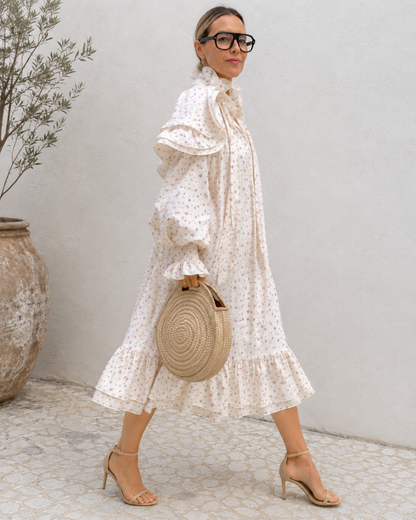 Side view of cream floral puff sleeve midi dress with flowing silhouette