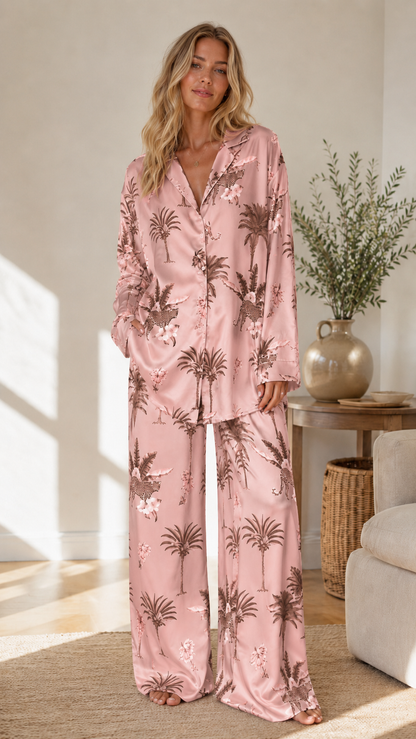 Woman wearing blush pink tropical print satin-look pajama set with long sleeve button-front top