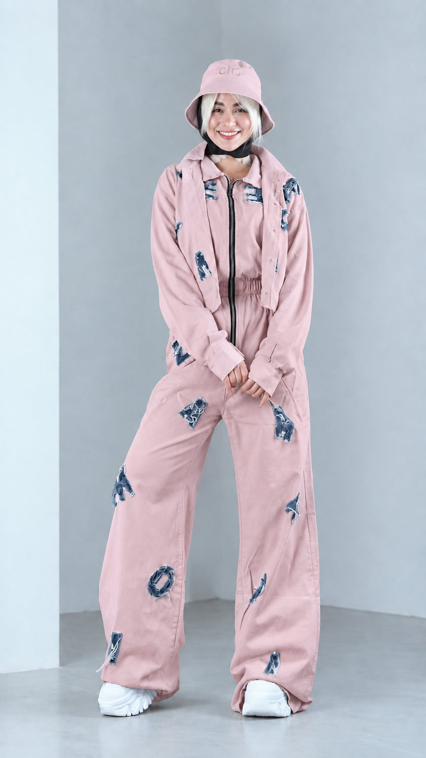 Full front view of model in dusty pink distressed two-piece jacket and pants set