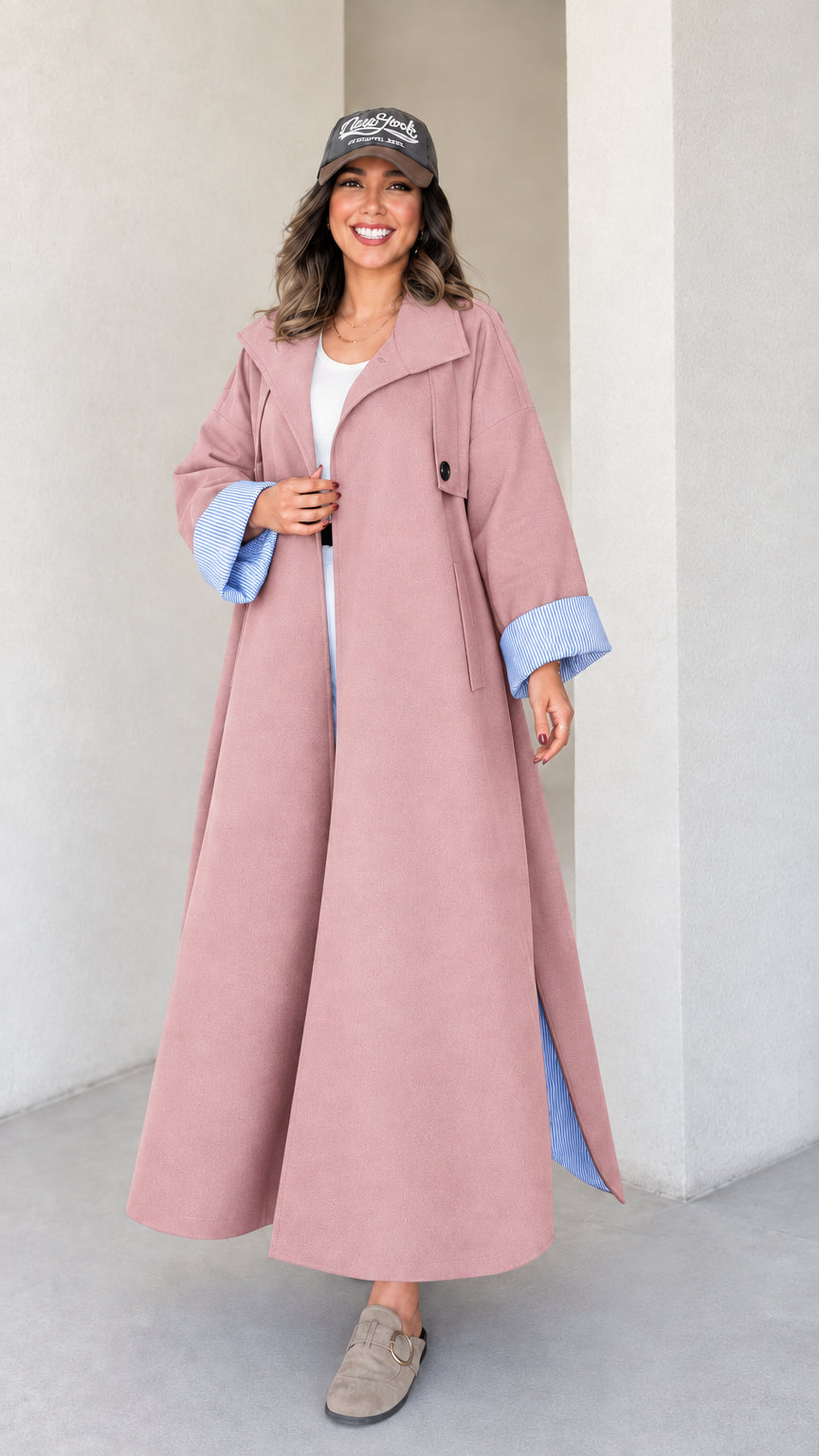 Full-length studio shot of woman wearing dusty pink maxi trench duster coat
