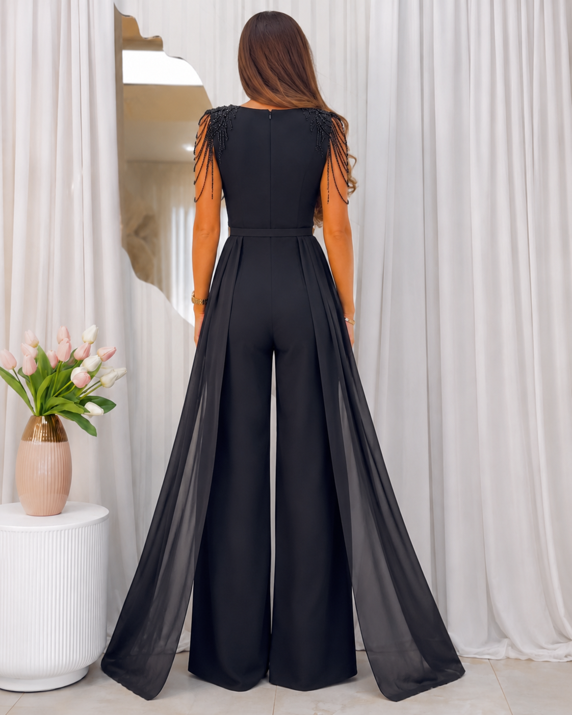 Back view of black sleeveless jumpsuit with shoulder strand detail