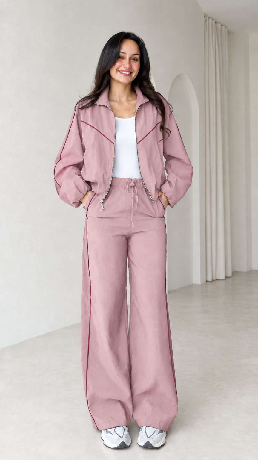 Model wearing dusty pink zip track jacket and wide leg pants set