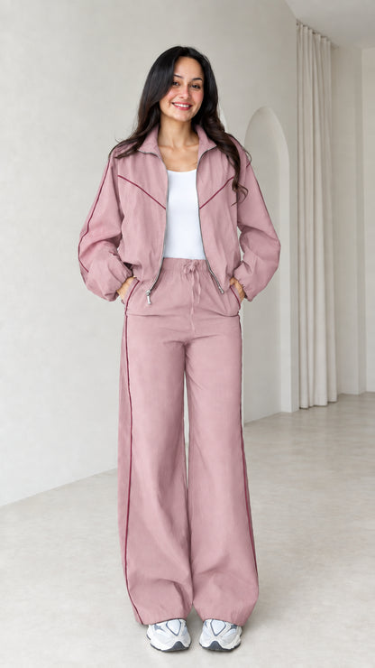 Model wearing dusty pink zip track jacket and wide leg pants set