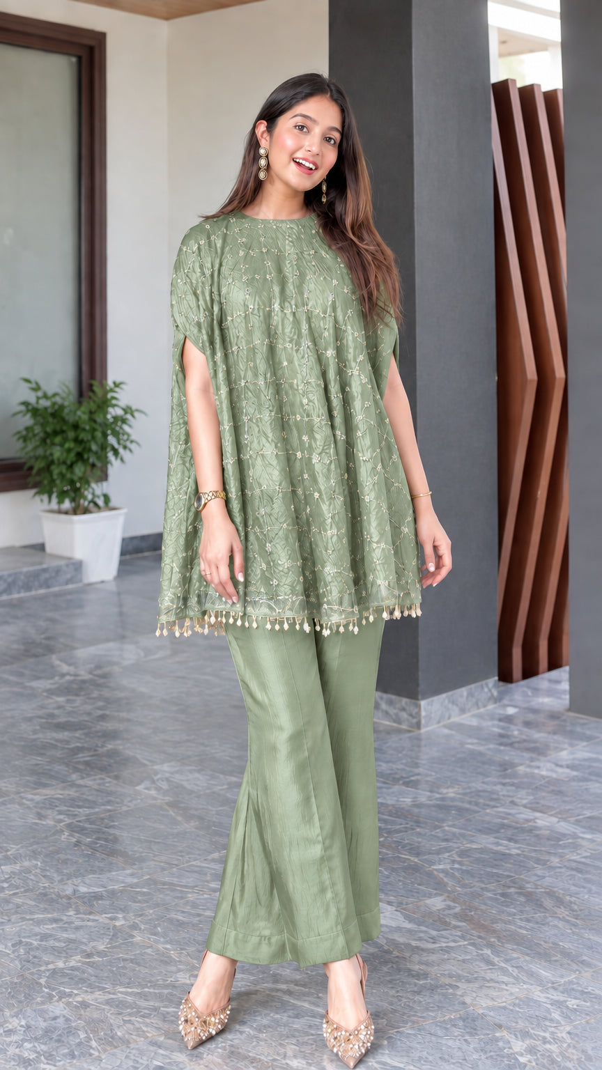 Model wearing sage green embroidered cape tunic and matching flared trousers