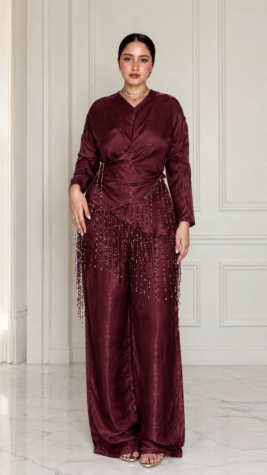 Full-length view of model wearing Burgundy satin draped two-piece set with beaded trim
