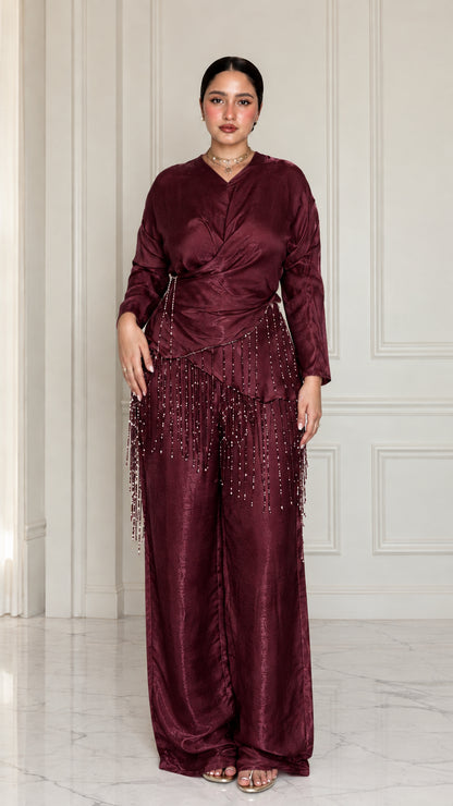 Full-length view of model wearing Burgundy satin draped two-piece set with beaded trim
