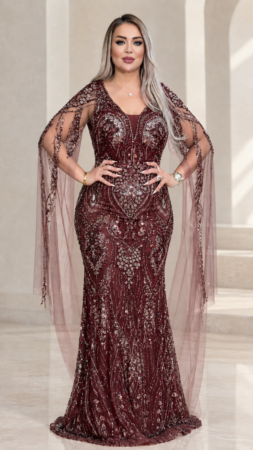 Front view of burgundy red embellished formal gown with cape sleeves