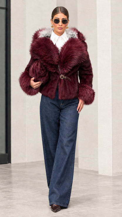 Woman wearing deep burgundy plush hooded short jacket with matching fur trim