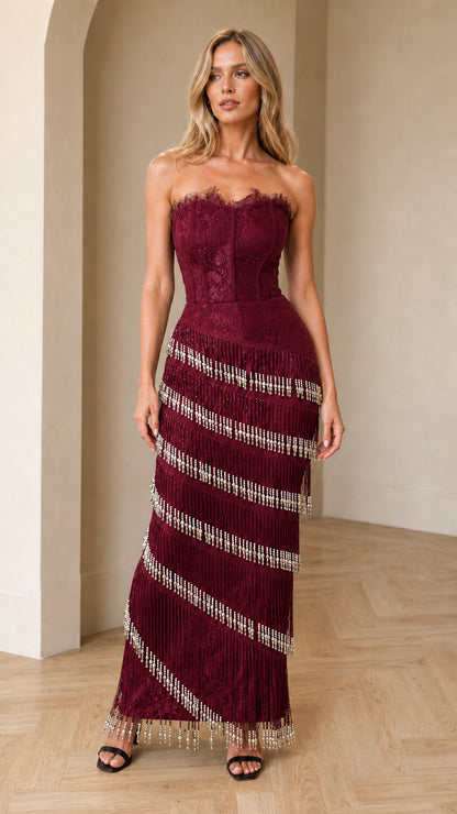 Model wearing burgundy wine strapless lace corset beaded fringe maxi dress