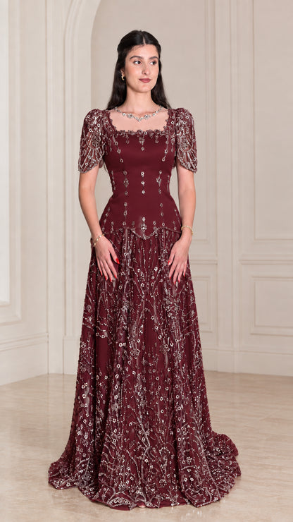 Model wearing rich Burgundy beaded floor-length gala dress