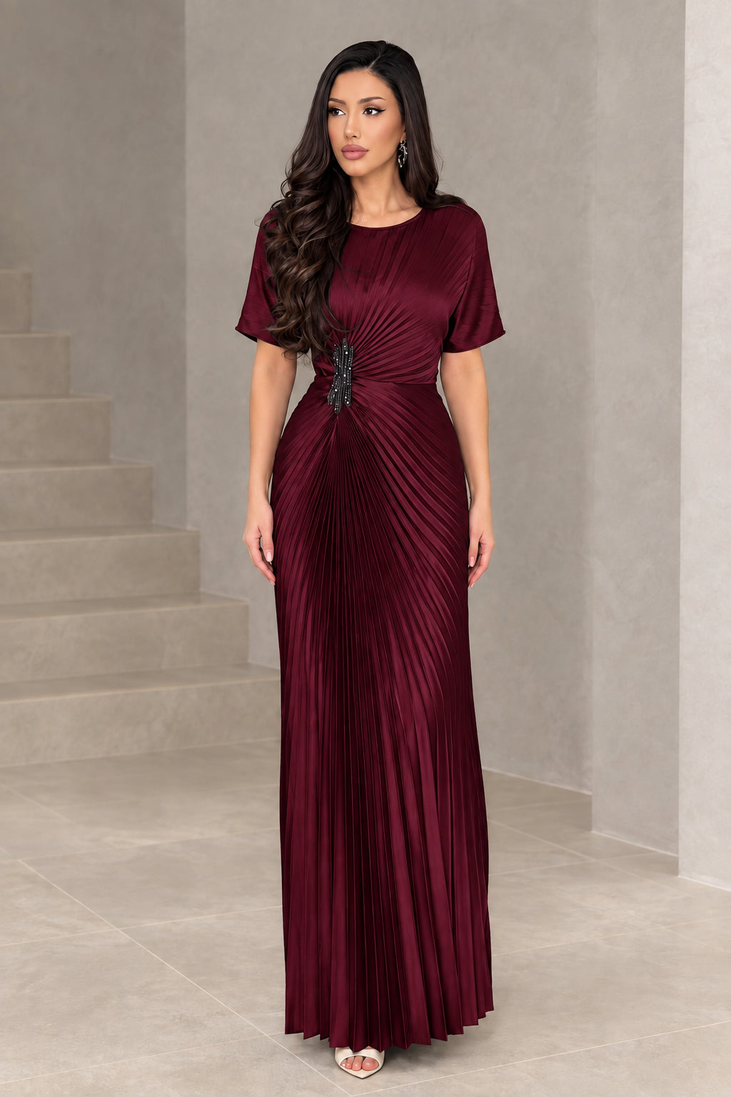 Front full-length view of woman wearing burgundy pleated short sleeve maxi gown