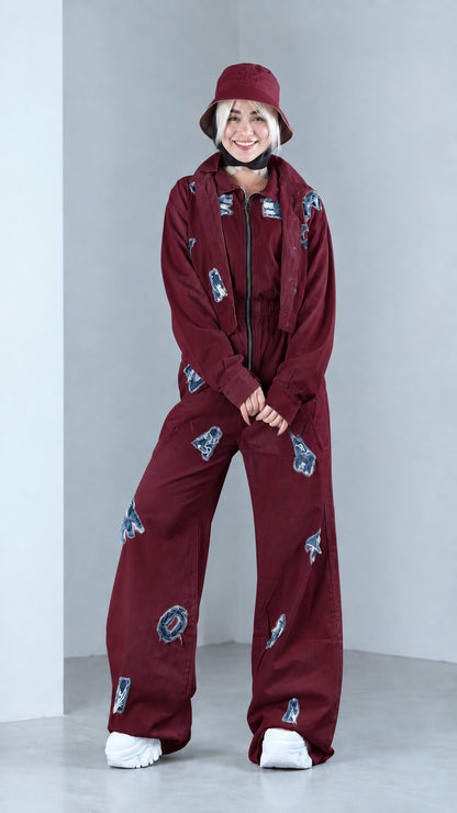 Full front view of model in burgundy distressed two-piece jacket and pants set