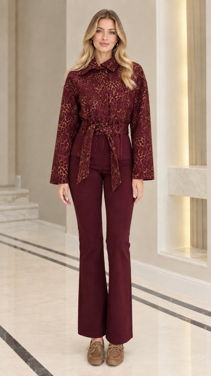 Front view of model wearing burgundy wine red textured jacquard belted jacket