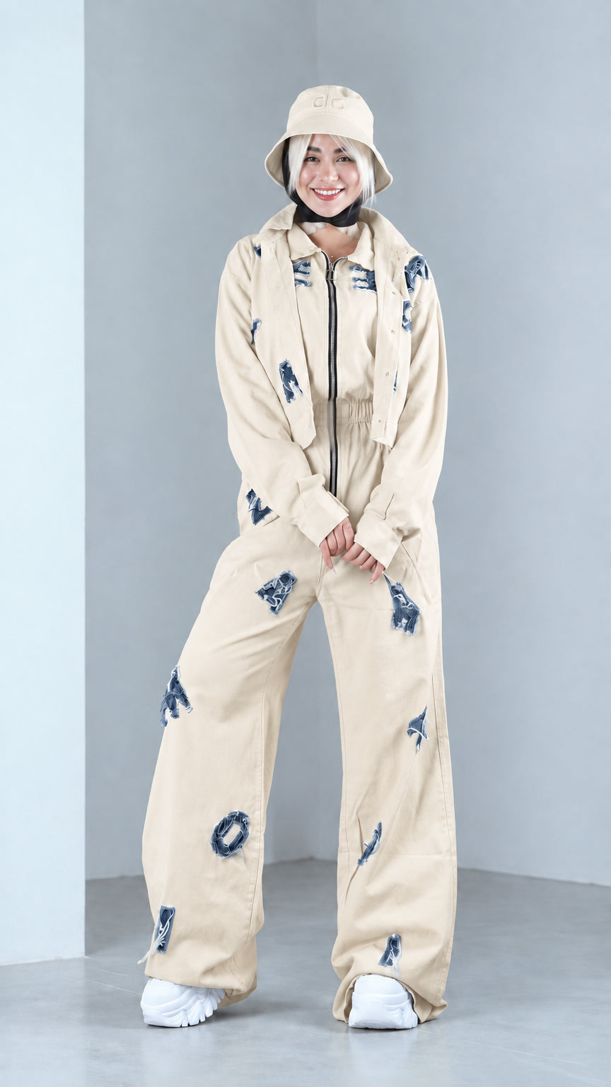 Full front view of model in beige distressed two-piece jacket and pants set